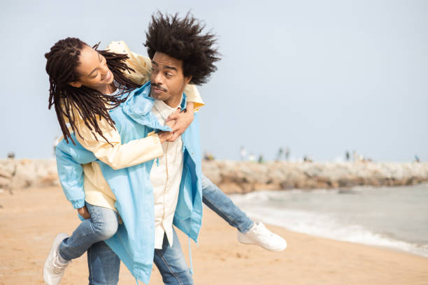 istock Happy Afro couple having fun on the beach and taking a selfie 1487857719