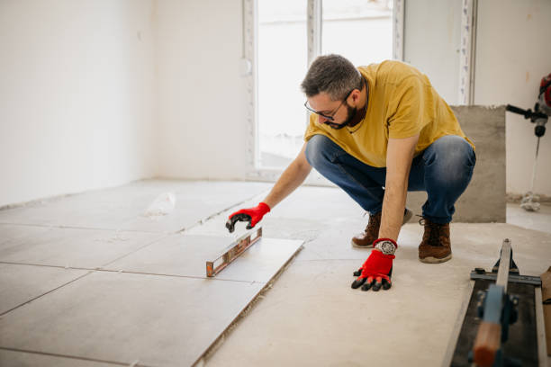 istock Worker in overalls puts tiles on the  wall 1487857769