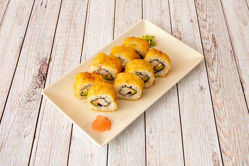 Uramaki california roll fried breaded stuffed with surimi and avocado with wasabi and ginseng
