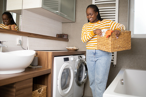 Young woman doing her laundry at home