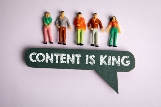 CONTENT IS KING CONCEPT. Miniature human figures and speech bubble on a white background
