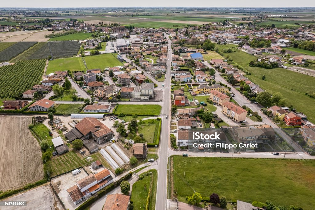 Aerial View of a Small Village in the Po Valley Countryside Captivating aerial perspective of a quaint village nestled amidst the lush, green Po Valley farmlands in Italy. Villanova del Ghebbo. Small Town Stock Photo
