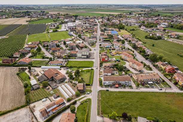 Aerial View of a Small Village in the Po Valley Countryside Captivating aerial perspective of a quaint village nestled amidst the lush, green Po Valley farmlands in Italy. Villanova del Ghebbo. charming stock pictures, royalty-free photos & images