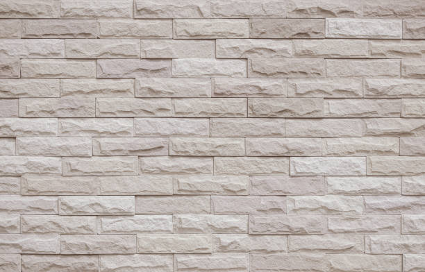 istock Cream and beige brick wall texture background. Brickwork and stonework flooring interior rock old pattern clean concrete grid uneven bricks office design. Background of old vintage brick wall backdrop 1487867481