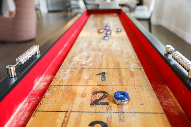 istock Shuffleboard is a game of precision and strategy, where players slide weighted discs down a narrow court to reach scoring areas. The sport represents the pursuit of accuracy and patience 1487870756