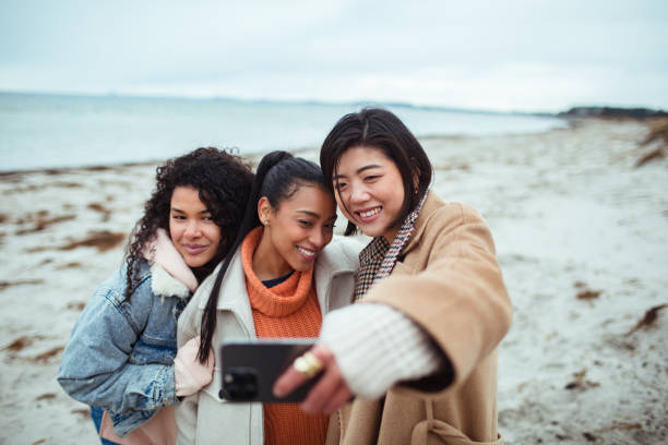 istock Three young women taking a selfie on a beach 1487878479
