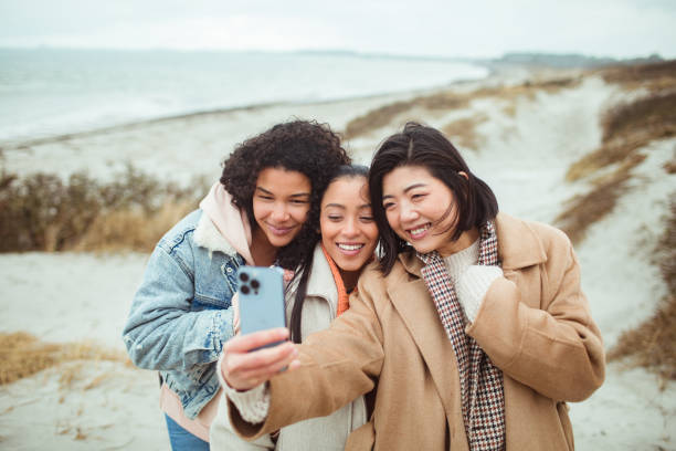 istock Three young women taking a selfie on a beach 1487878668