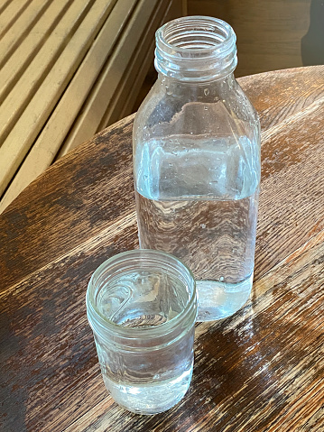 Water bottle and glass on a table top