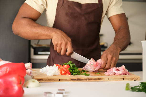 istock Unrecognizable young black man de-boning chicken to prepare a recipe. 1487881521