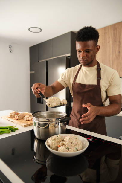 istock Young black man preparing boiled chicken mince with vegetables recipe. 1487881534