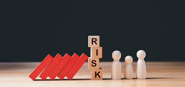Financial Crisis, Economic, Business Risk Management Concept. Risk word on wooden block, domino effect falling to family. Concept Risk, Crisis, Management, Assessment, Insurance, Security, Finance