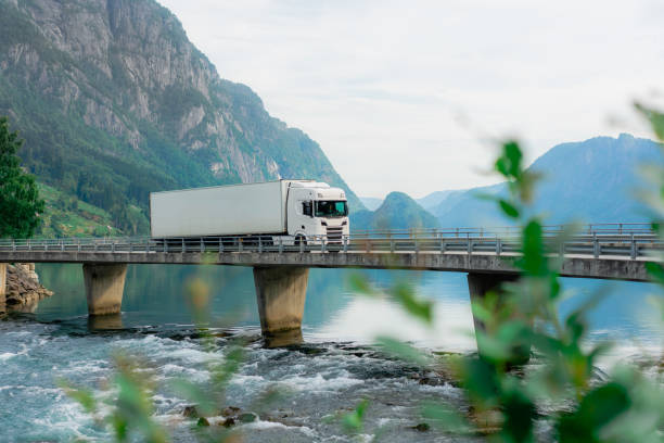 lkw auf der brücke über den fluss in norwegen - mountain mountain range norway fjord stock-fotos und bilder