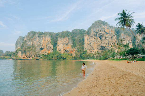 Young man making a finger heart on the Railay beach in Thailand. His POV.