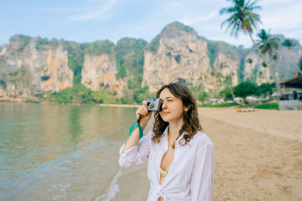 femme photographiant avec un appareil photo point and shoot sur la plage - appareil photo compact photos et images de collection
