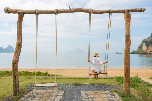 istock Woman on the swing on idyllic tropical beach 1487887330