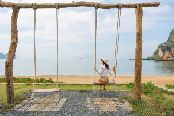 istock Woman on the swing on idyllic tropical beach 1487887335