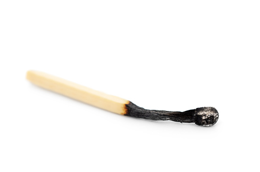 Burnt match on a white background. Close up.