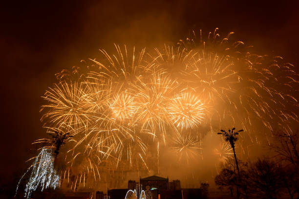 Beautiful yellow fireworks display lights up the sky with dazzling display during New Year celebration. Abstract colored fireworks background with copy space. Celebration and anniversary concept