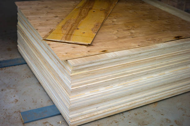 Rear view of a worker who takes chipboard and prepares it for processing, the process of making furniture