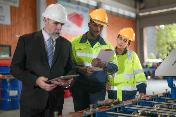 istock Senior boss manager talking staff engineer assistant woman and African man.Team engineering inspection check control heavy machine construction installation in industrial factory with boss manager. 1487891958