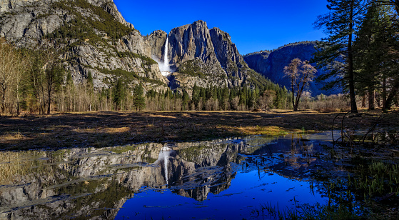 View of Yosemite Falls with a snow cone and a reflection in the spring in the Yosemite National Park, Sierra Nevada mountain range in California, USA