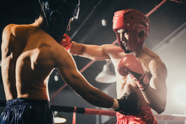 istock Boxer use various punch combinations, including the jab, hook, uppercut, cross, swing, straight. Getting in close to make opponent on ropes and knockout. Boxing champions win the round in boxing ring 1487900706