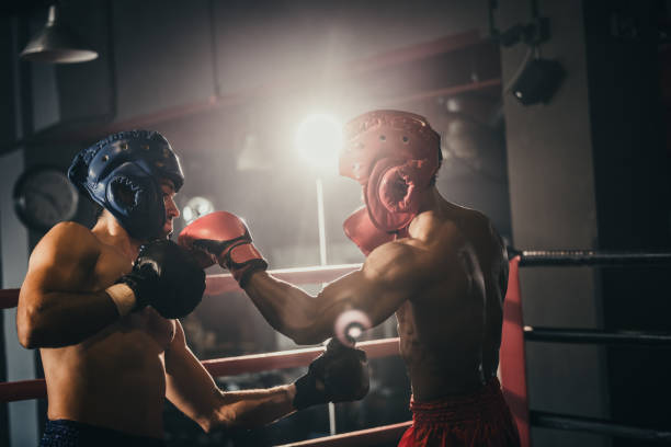 istock Boxer use various punch combinations, including the jab, hook, uppercut, cross, swing, straight. Getting in close to make opponent on ropes and knockout. Boxing champions win the round in boxing ring 1487900725