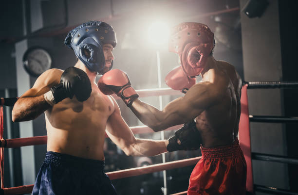 istock Boxer use various punch combinations, including the jab, hook, uppercut, cross, swing, straight. Getting in close to make opponent on ropes and knockout. Boxing champions win the round in boxing ring 1487900726