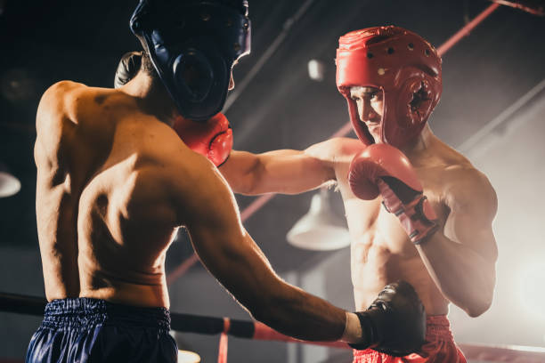 istock Boxer use various punch combinations, including the jab, hook, uppercut, cross, swing, straight. Getting in close to make opponent on ropes and knockout. Boxing champions win the round in boxing ring 1487900728
