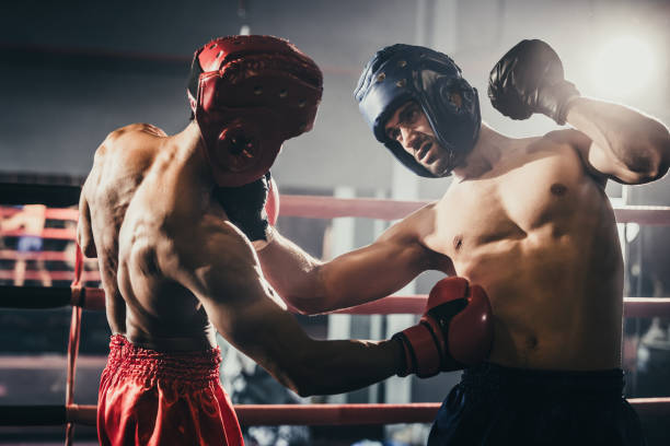 istock Boxer use various punch combinations, including the jab, hook, uppercut, cross, swing, straight. Getting in close to make opponent on ropes and knockout. Boxing champions win the round in boxing ring 1487901252