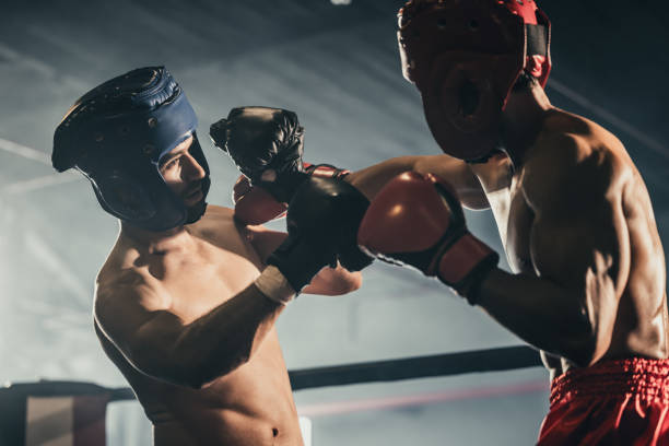istock Boxer use various punch combinations, including the jab, hook, uppercut, cross, swing, straight. Getting in close to make opponent on ropes and knockout. Boxing champions win the round in boxing ring 1487901283