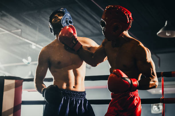 istock Boxer use various punch combinations, including the jab, hook, uppercut, cross, swing, straight. Getting in close to make opponent on ropes and knockout. Boxing champions win the round in boxing ring 1487901388