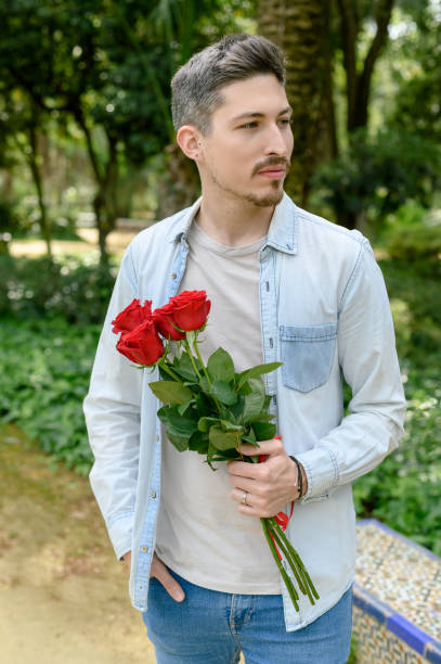 istock Guy holding red roses on street 1487902316