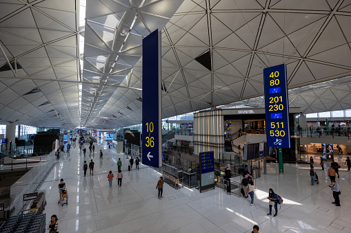 Hong Kong - April 17, 2023 : People at Hong Kong International Airport. The airport has been commercially operational since 1998. It is operated by the Airport Authority Hong Kong.