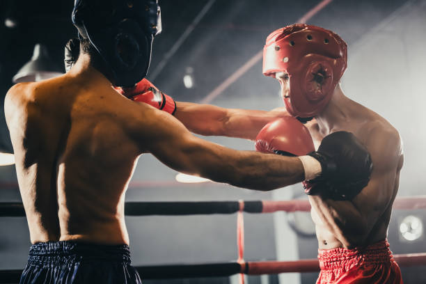 istock Boxer use various punch combinations, including the jab, hook, uppercut, cross, swing, straight. Getting in close to make opponent on ropes and knockout. Boxing champions win the round in boxing ring 1487902717