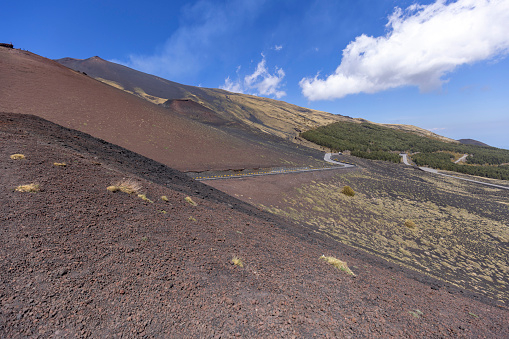 Beautiful general view of the slopes of the volcano Mount Etna on the sunny day, Sicily, Italy. Stones and solidified lava, withered vegetation