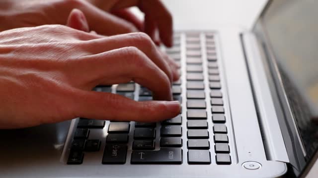 Male hands typing on laptop keyboard