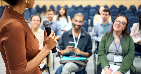 Cropped shot of a businesswoman holding a mic speaking to group of audience during a business conference