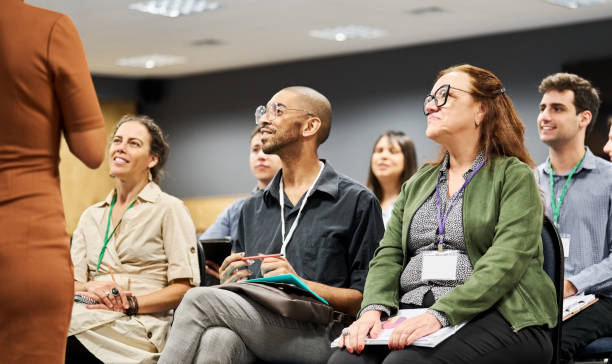 Multiracial group of businesspeople attending a conference event Multiracial group of businesspeople listening to a speaker during a conference event at convention center middle age adult studying stock pictures, royalty-free photos & images