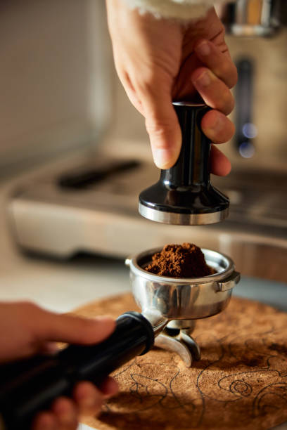 istock A waiter holding a portafilter and a coffee tamper making an espresso coffee. 1487908764
