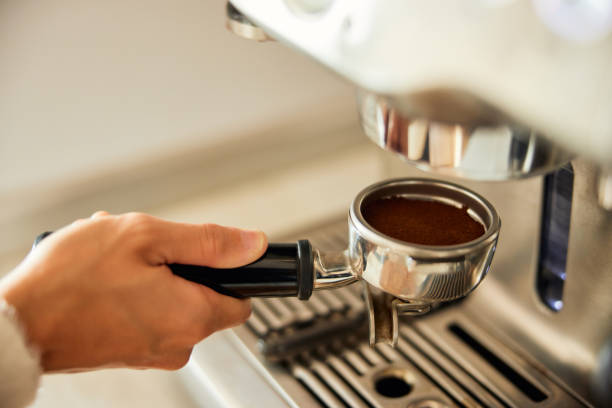 istock A woman holding a coffee holder with ground coffee, and making espresso. 1487908766