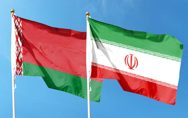 istock Iran flag and Belarus flag on cloudy sky. waving in the sky 1487910123