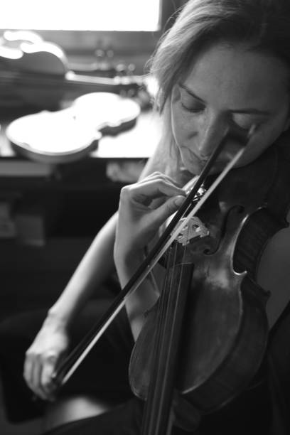 istock Young beautiful woman violin player playing violin, black and white 1487910604
