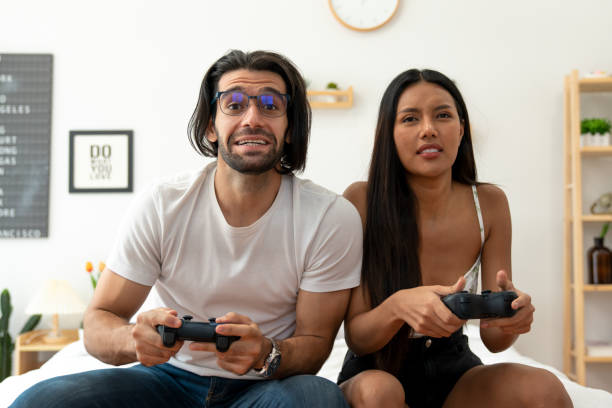 istock Ethnicity couple use  game controller playing excited video game in bedroom 1487912945