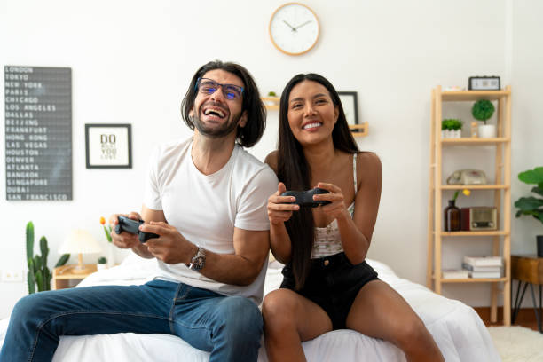 istock Ethnicity couple use  game controller playing excited video game in bedroom 1487912955