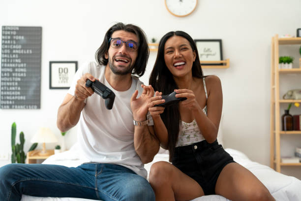 istock Ethnicity couple use  game controller playing excited video game in bedroom 1487912958