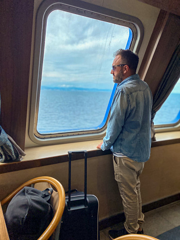 Serious latin man contemplating the sea view from inside a boat