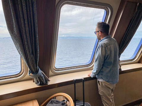 Serious latin man contemplating the sea view from inside a boat