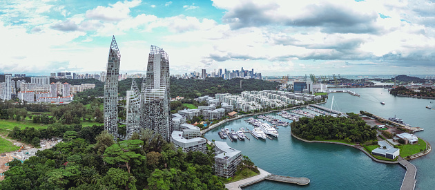 The Keppel Bay area in Singapore is a modern, luxury residential district full of skyscrapers, big yachts in the marina and tropical rainforest.