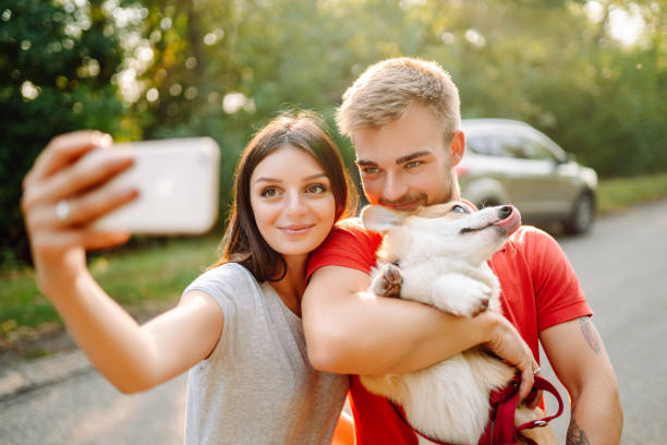 istock Young couple together with their beloved pet on a walk doing selfie 1487915252